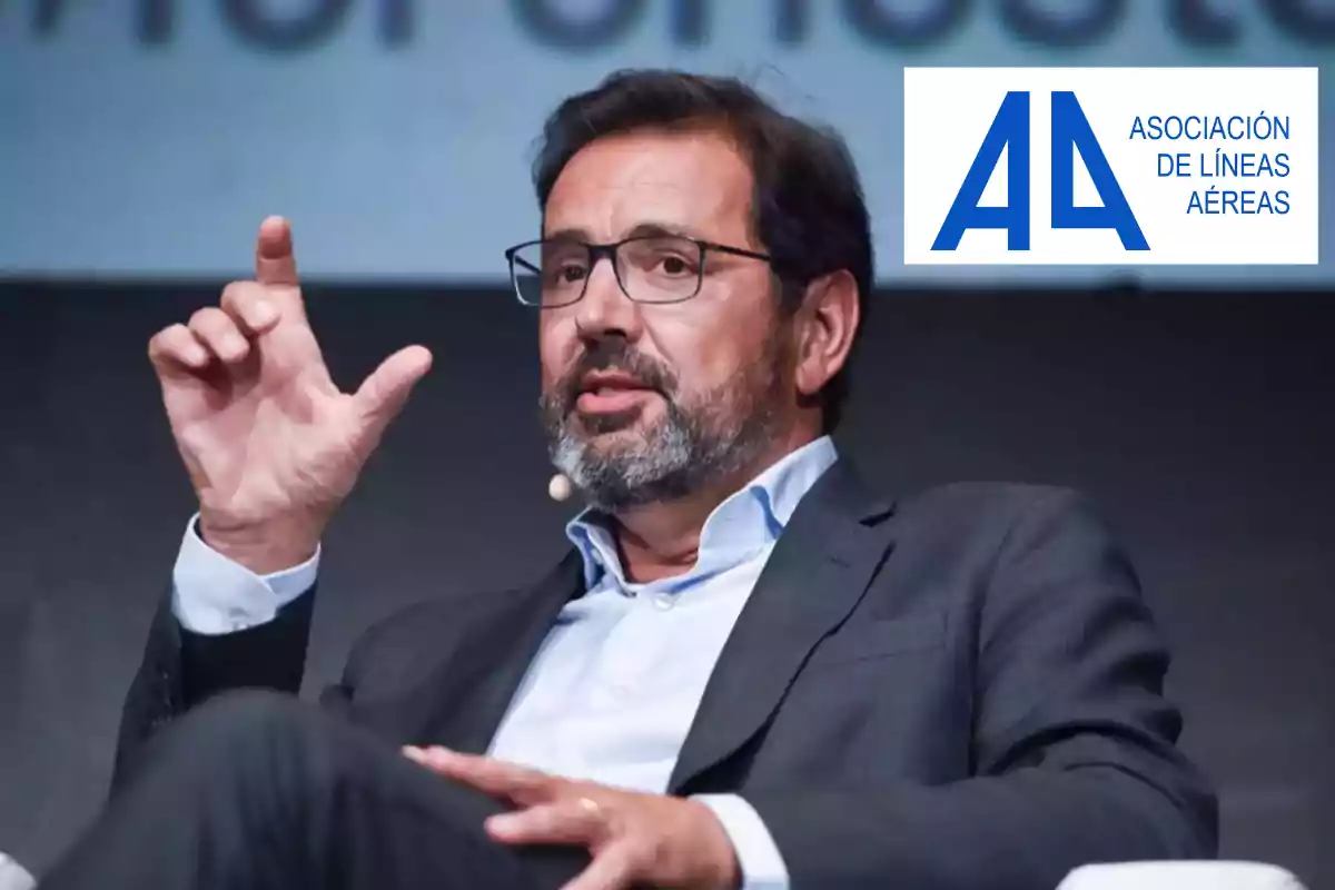 Hombre con barba y gafas hablando en un evento con el logo de la Asociación de Líneas Aéreas en la esquina superior derecha