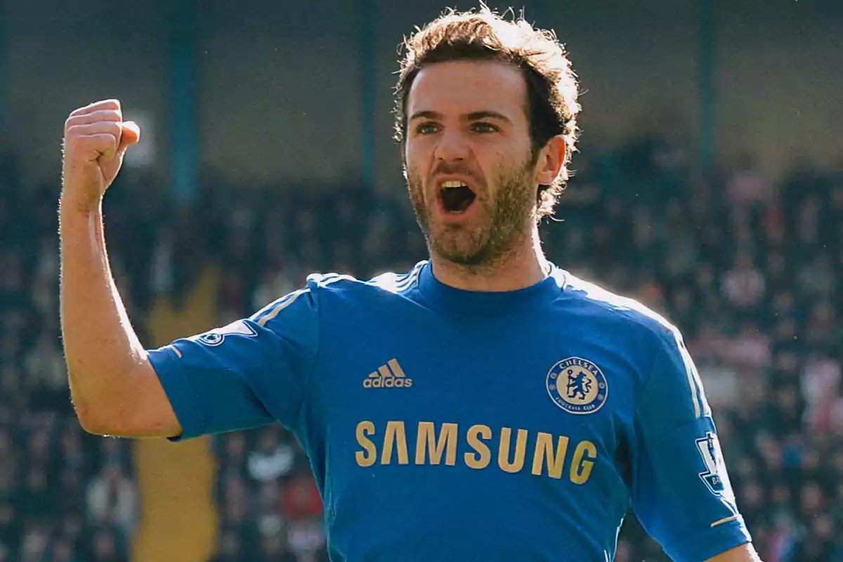 Futbolista con uniforme azul del Chelsea celebrando con el puño en alto en un estadio Futbolista con uniforme azul del Chelsea celebrando con el puño en alto en un estadio