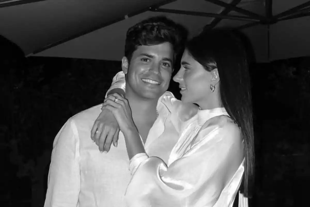 Pareja joven abrazándose y sonriendo en una foto en blanco y negro