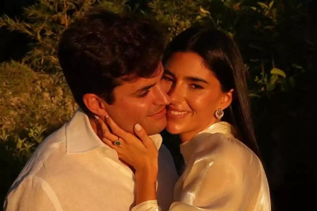 Pareja abrazándose y sonriendo al atardecer con fondo de vegetación Pareja abrazándose y sonriendo al atardecer con fondo de vegetación