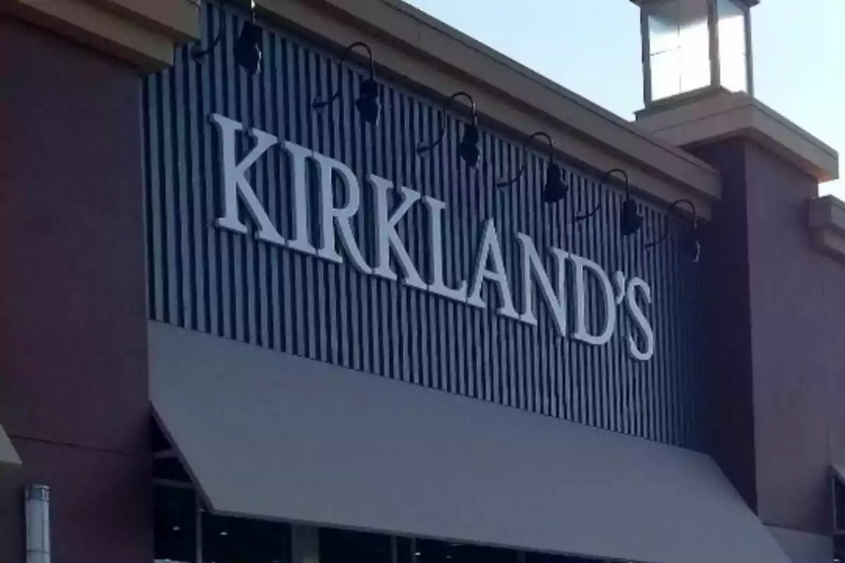 Fachada de una tienda Kirkland's con letras grandes y toldo gris Fachada de una tienda Kirkland's con letras grandes y toldo gris