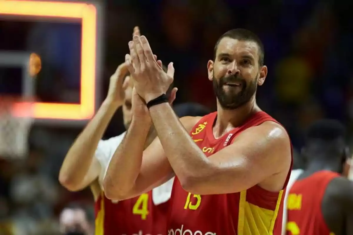 Jugador de baloncesto con uniforme rojo aplaudiendo en una cancha durante un partido Jugador de baloncesto con uniforme rojo aplaudiendo en una cancha durante un partido