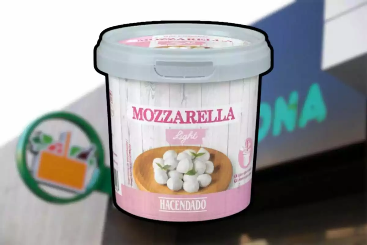 Envase de mozzarella light de la marca Hacendado frente a un cartel de supermercado desenfocado Envase de mozzarella light de la marca Hacendado frente a un cartel de supermercado desenfocado