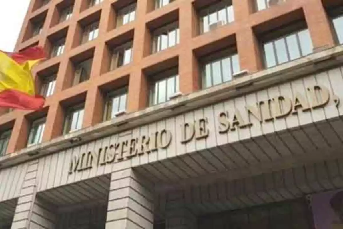 Fachada del edificio del Ministerio de Sanidad de España con una bandera española ondeando a la izquierda