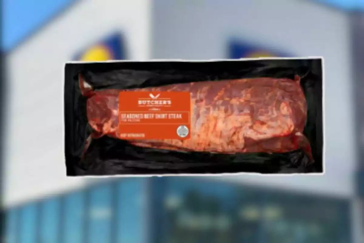 Un paquete de carne de res sazonada al vacío con una etiqueta naranja sobre un fondo borroso de un edificio. Un paquete de carne de res sazonada al vacío con una etiqueta naranja sobre un fondo borroso de un edificio.