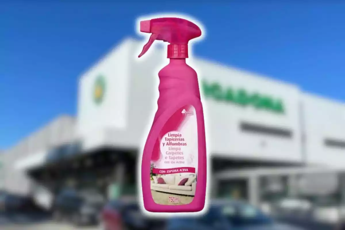 Botella de limpiador rosa para tapicerías y alfombras de Mercadona frente a una tienda con fachada blanca y letras verdes desenfocadas. Botella de limpiador rosa para tapicerías y alfombras de Mercadona frente a una tienda con fachada blanca y letras verdes desenfocadas.