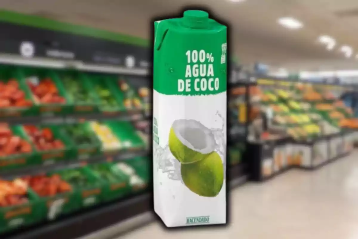 Envase de agua de coco de la marca Hacendado en un supermercado con fondo de frutas y verduras desenfocado. Envase de agua de coco de la marca Hacendado en un supermercado con fondo de frutas y verduras desenfocado.