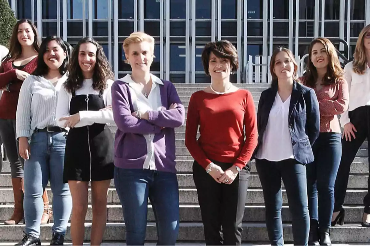 Grupo de mujeres posando en una escalera frente a un edificio moderno Grupo de mujeres posando en una escalera frente a un edificio moderno