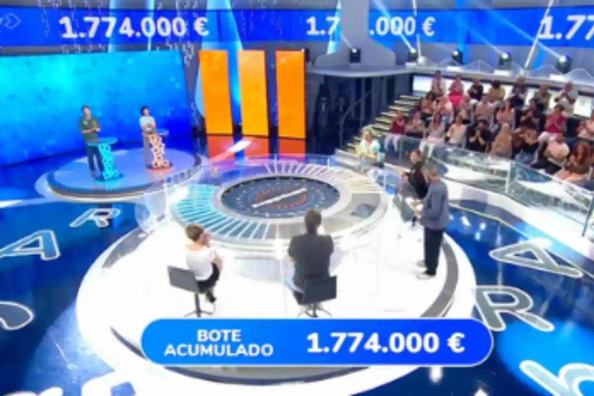 Plano general de 'Pasapalabra' con concursantes, presentador, público y un bote acumulado de un millón setecientos setenta y cuatro mil euros en pantalla. Plano general de 'Pasapalabra' con concursantes, presentador, público y un bote acumulado de un millón setecientos setenta y cuatro mil euros en pantalla.
