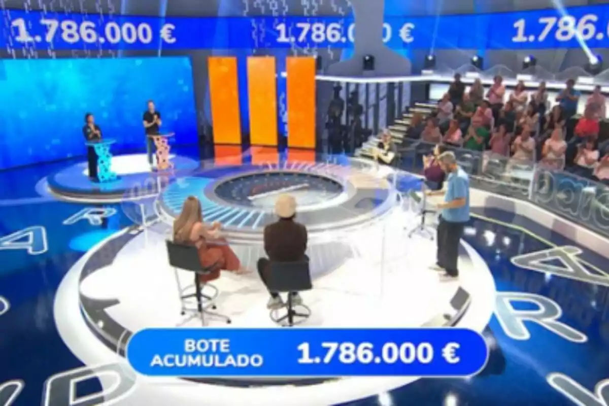 Plató televisivo de 'Pasapalabra' con participantes, público y un bote acumulado de un millón setecientos ochenta y seis mil euros en pantalla. Plató televisivo de 'Pasapalabra' con participantes, público y un bote acumulado de un millón setecientos ochenta y seis mil euros en pantalla.