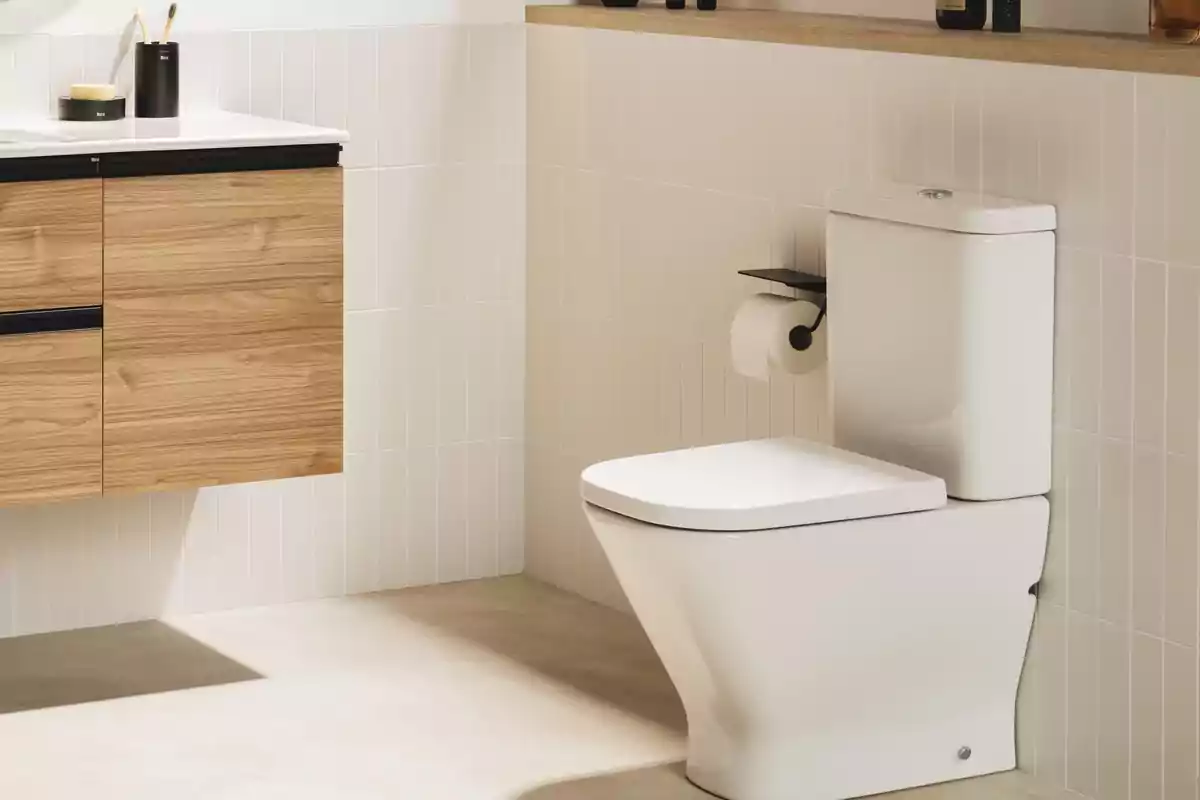 Baño moderno con inodoro blanco y mueble de madera clara Baño moderno con inodoro blanco y mueble de madera clara