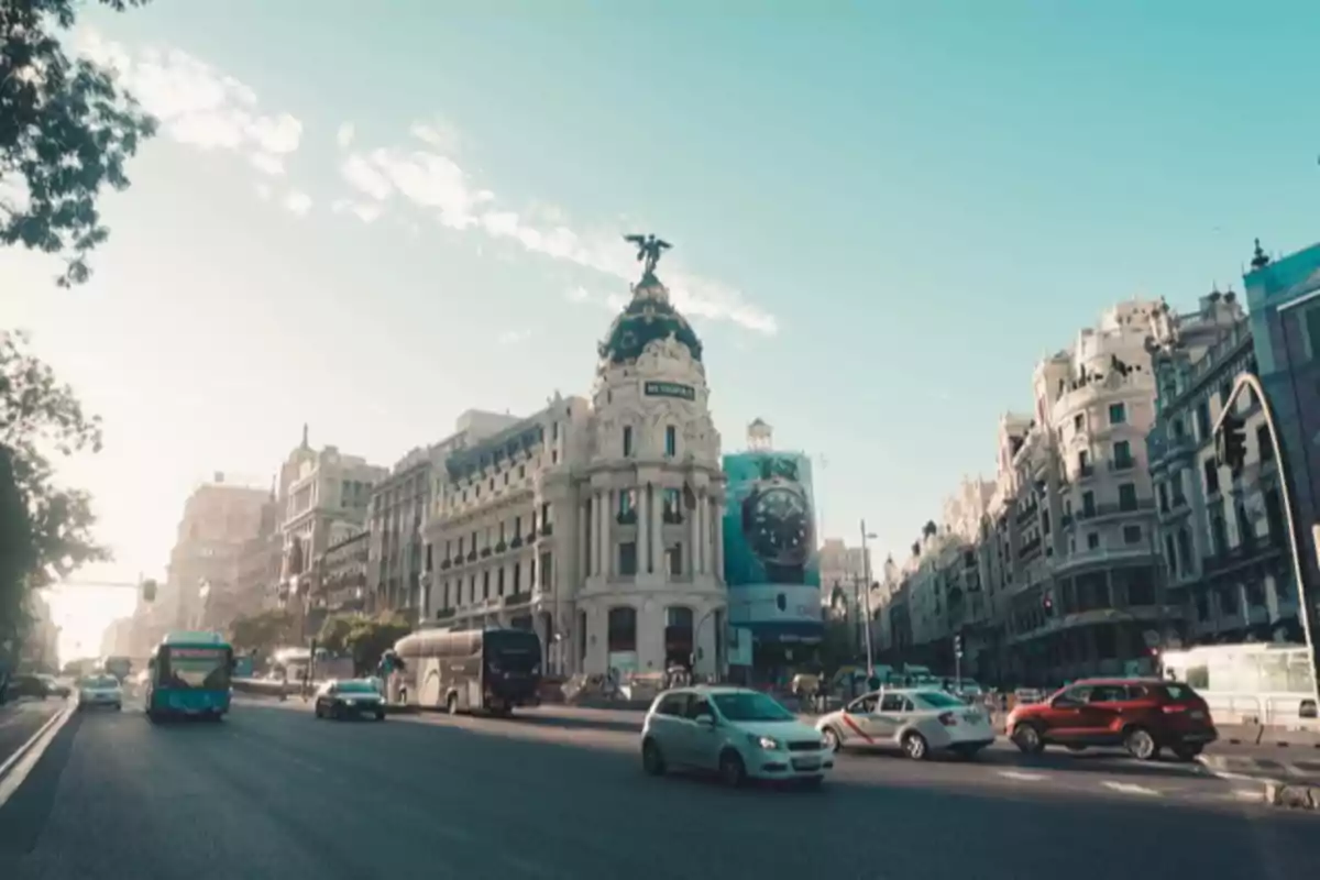 Tráfico y edificios históricos en la Gran Vía de Madrid bajo un cielo despejado