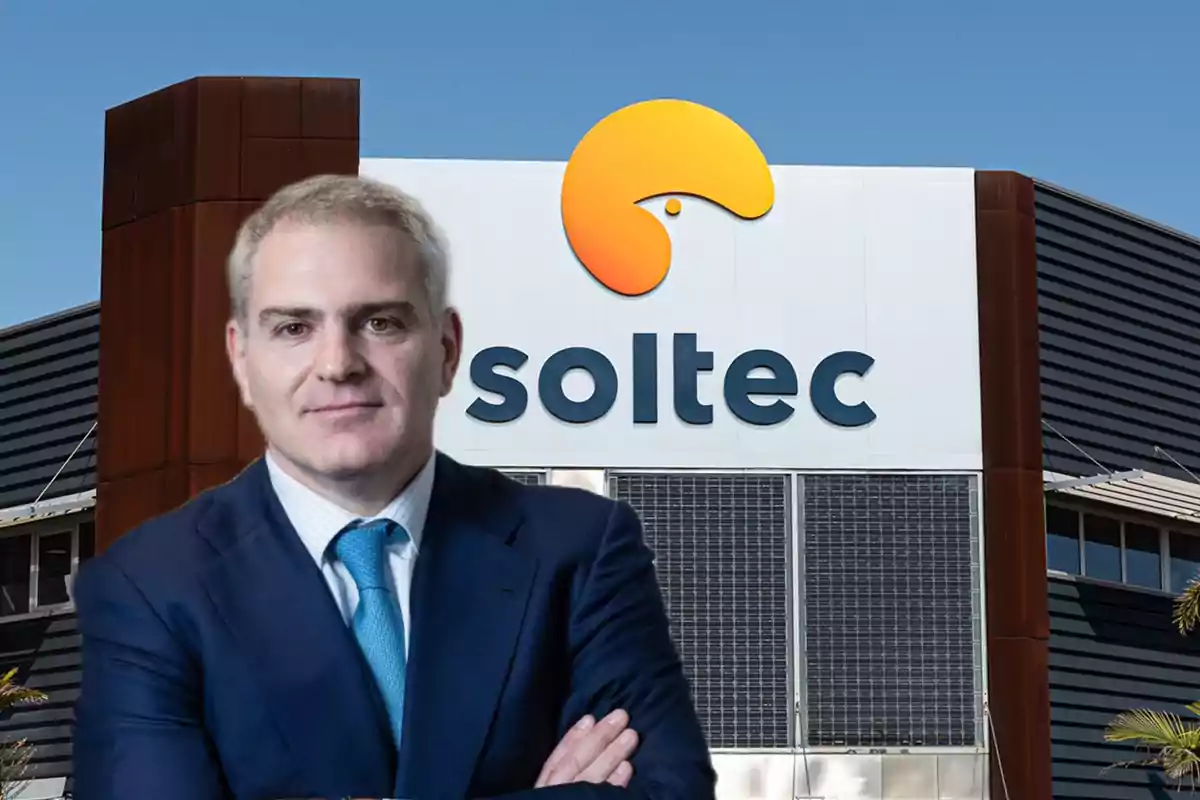 Hombre de traje azul con corbata celeste posando frente a un edificio con el logo y nombre de la empresa Soltec