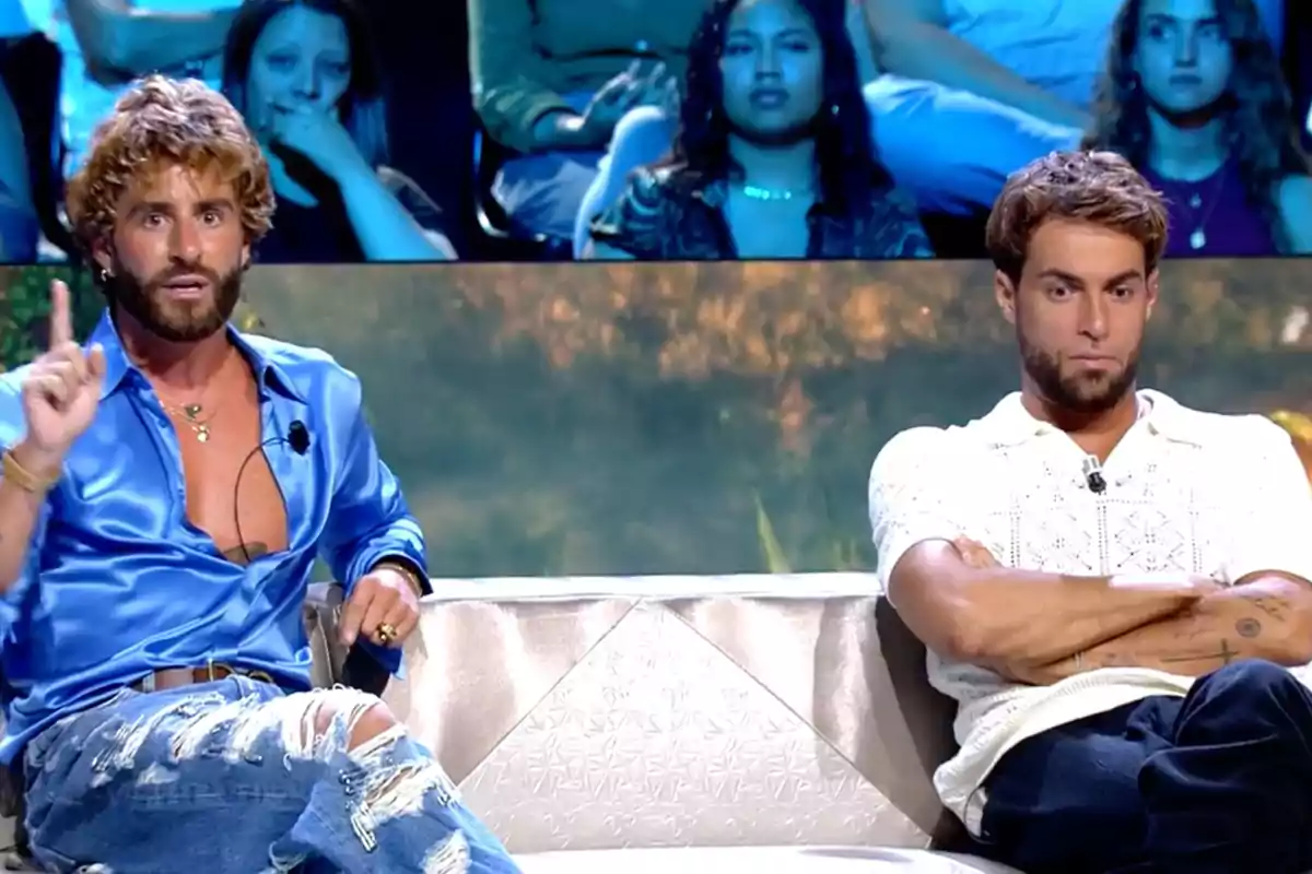 Pelayo Díaz y Montoya sentados en un sofá durante un programa de televisión, uno de ellos viste una camisa azul brillante y gesticula con la mano, mientras el otro lleva una camiseta blanca y tiene los brazos cruzados, al fondo se ve al público observando atentamente. Captura de 'Supervivientes' Pelayo Díaz y Montoya sentados en un sofá durante un programa de televisión, uno de ellos viste una camisa azul brillante y gesticula con la mano, mientras el otro lleva una camiseta blanca y tiene los brazos cruzados, al fondo se ve al público observando atentamente. Captura de 'Supervivientes'