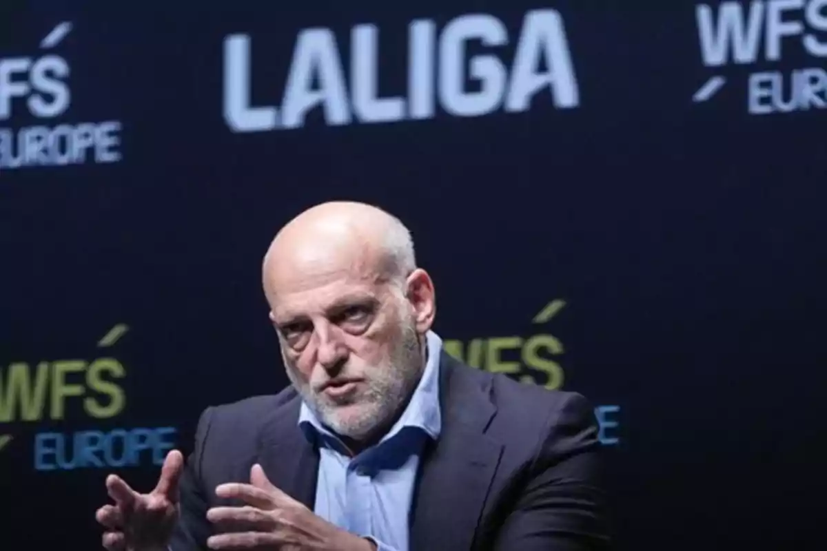 Hombre calvo con barba canosa hablando gesticulando con las manos frente a un fondo negro con los textos LALIGA y WFS EUROPE Hombre calvo con barba canosa hablando gesticulando con las manos frente a un fondo negro con los textos LALIGA y WFS EUROPE