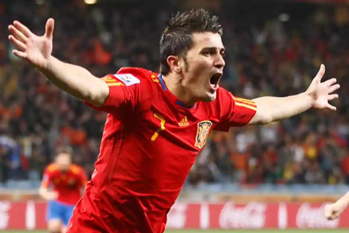 Futbolista español celebrando un gol con los brazos abiertos durante un partido