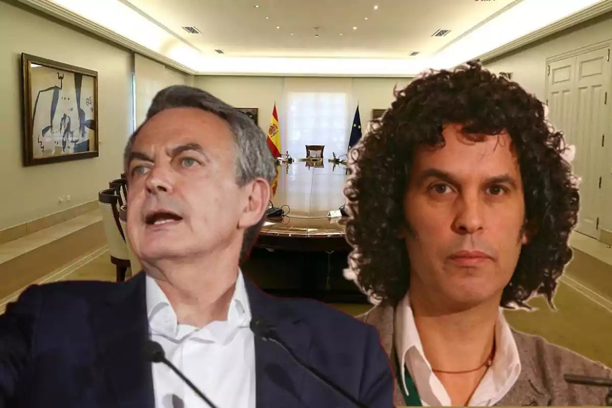 Dos hombres en primer plano frente a una sala de reuniones con una mesa grande y banderas de España y la Unión Europea al fondo