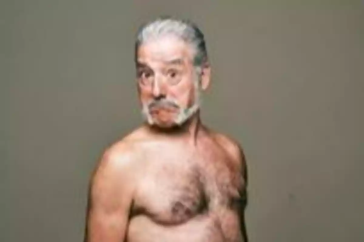 Hombre mayor de cabello canoso y barba posando sin camisa con expresión divertida Hombre mayor de cabello canoso y barba posando sin camisa con expresión divertida