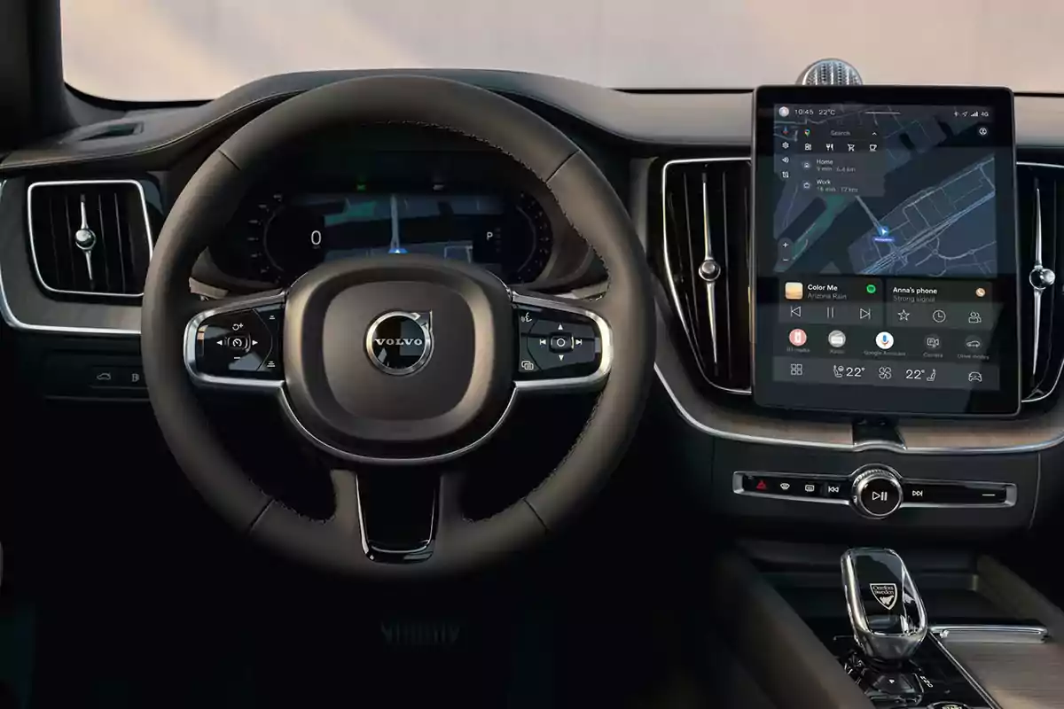 Volante y tablero digital de un auto Volvo con una pantalla central mostrando un sistema de navegación y controles multimedia Volante y tablero digital de un auto Volvo con una pantalla central mostrando un sistema de navegación y controles multimedia