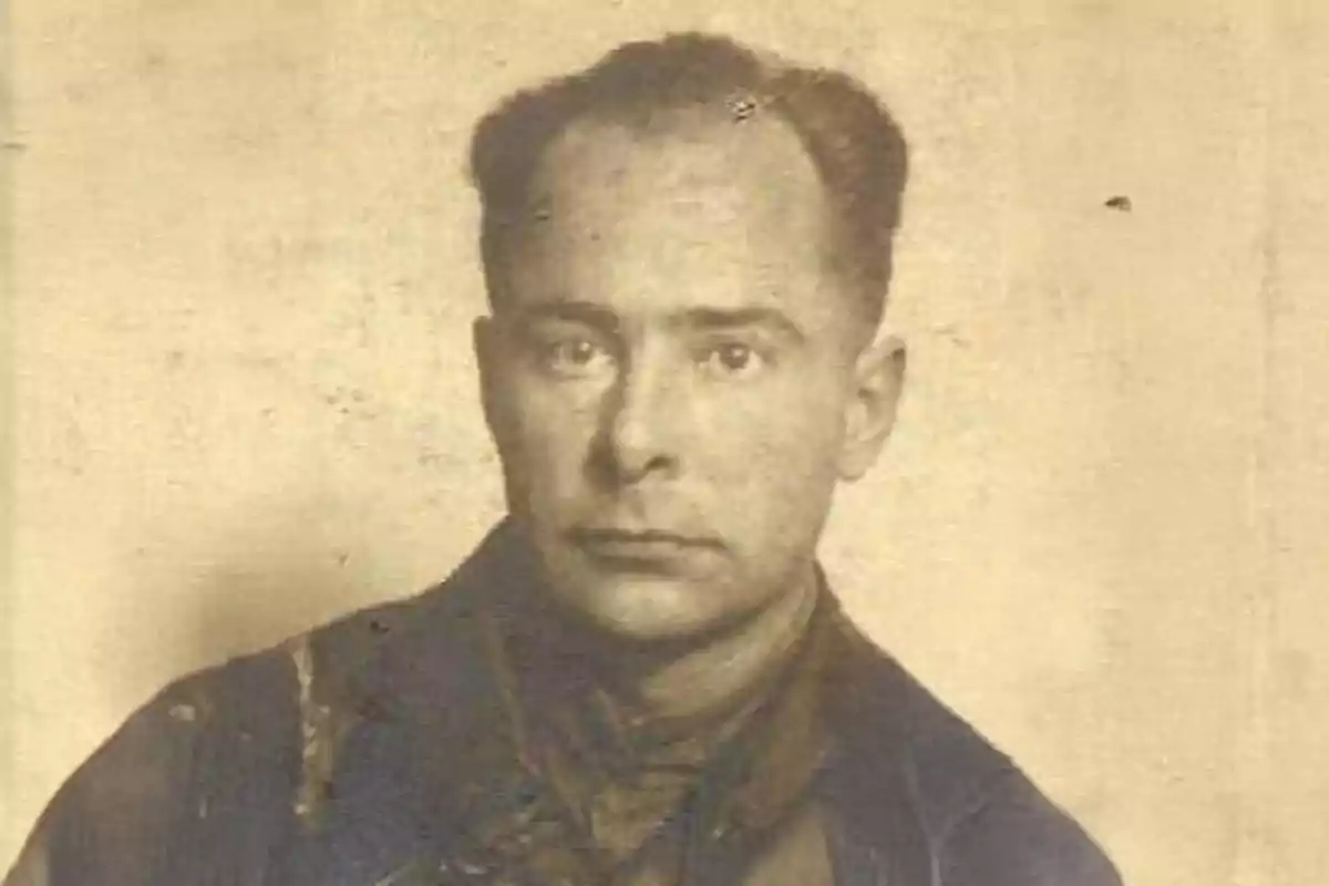Fotografía antigua en sepia de un hombre con expresión seria y cabello corto, vestido con ropa oscura y fondo liso. Fotografía antigua en sepia de un hombre con expresión seria y cabello corto, vestido con ropa oscura y fondo liso.