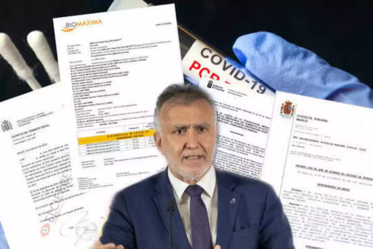Un hombre de traje habla frente a varios documentos oficiales y pruebas relacionadas con COVID-19