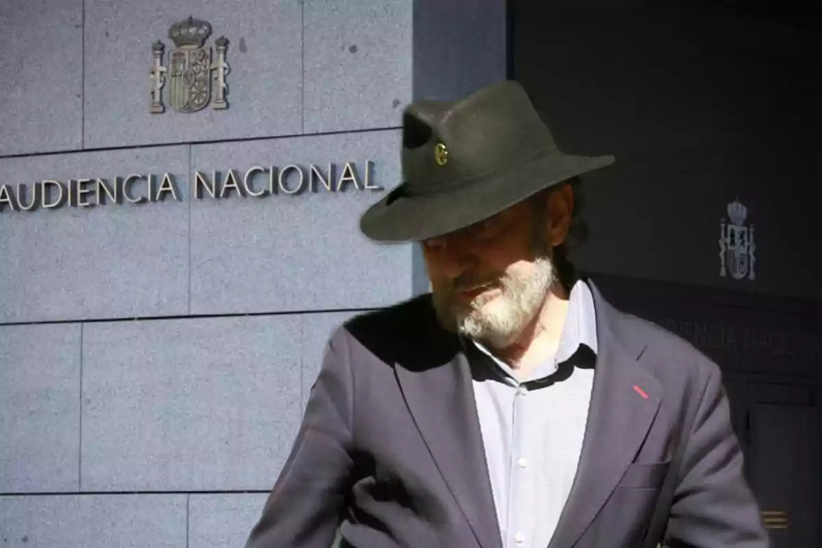 Hombre con barba y sombrero oscuro frente a un edificio con el letrero Audiencia Nacional