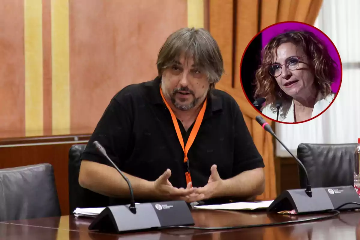 Un hombre de cabello canoso y barba está sentado en una mesa de conferencias hablando frente a un micrófono, mientras que en la esquina superior derecha aparece el retrato de una mujer con gafas y cabello rizado dentro de un círculo rojo