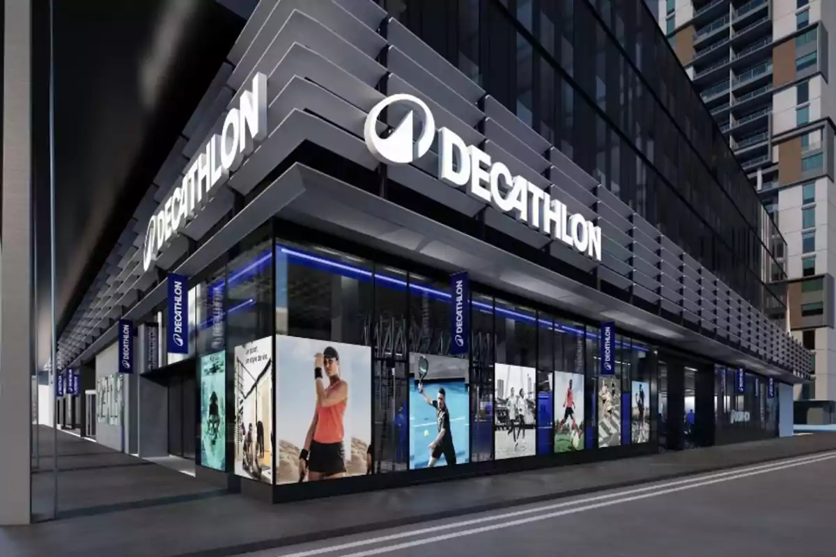 Fachada de una tienda Decathlon moderna con grandes ventanales y anuncios de deportes en la esquina de un edificio urbano Fachada de una tienda Decathlon moderna con grandes ventanales y anuncios de deportes en la esquina de un edificio urbano