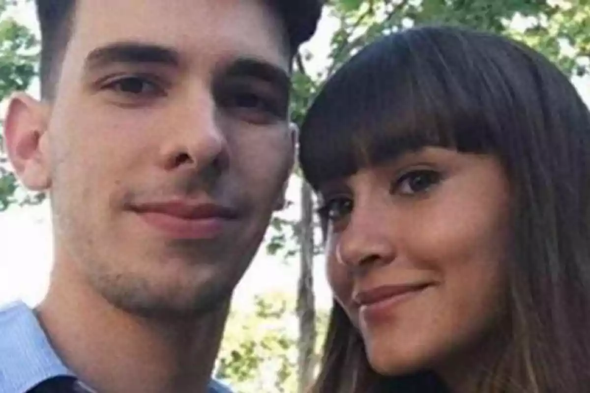 Una pareja joven sonríe mientras se toma una selfie al aire libre con árboles de fondo. Una pareja joven sonríe mientras se toma una selfie al aire libre con árboles de fondo.