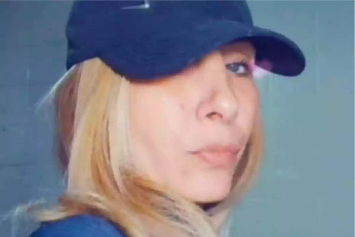 Mujer de cabello rubio usando una gorra negra mirando hacia la cámara con expresión seria Mujer de cabello rubio usando una gorra negra mirando hacia la cámara con expresión seria