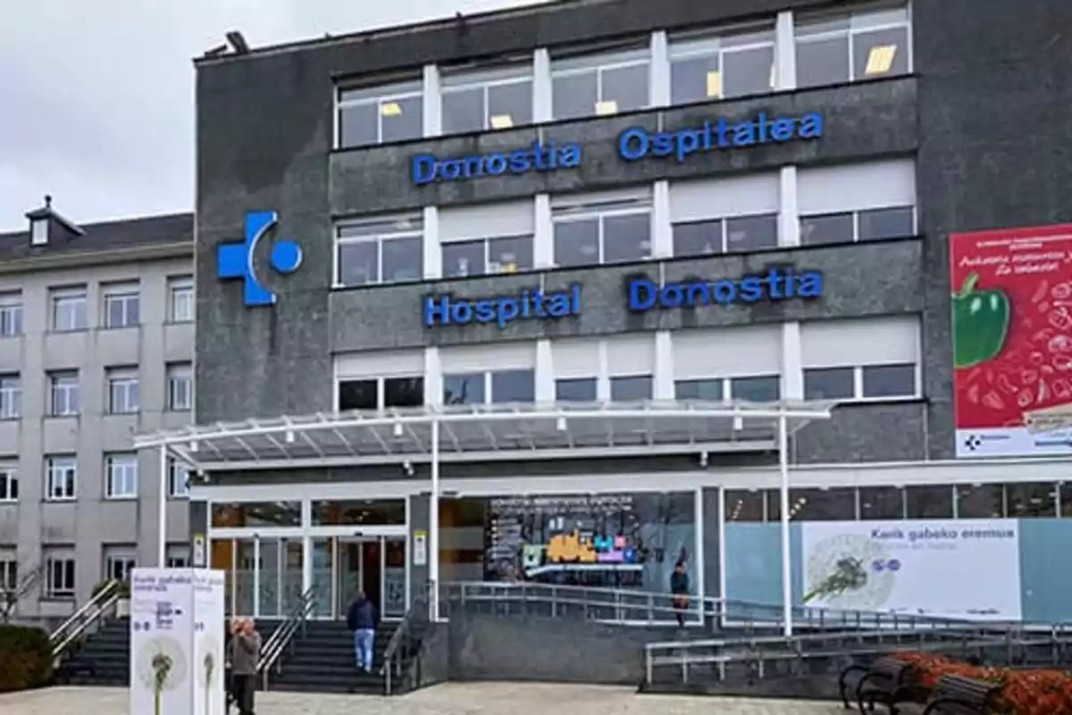 Fachada principal del Hospital Donostia con letreros en azul y personas entrando al edificio