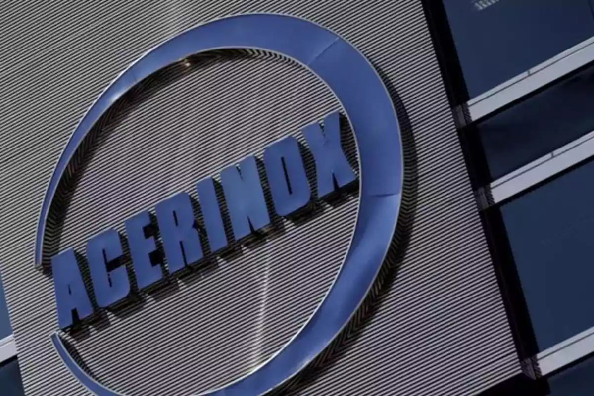 Logo de Acerinox en una fachada metálica con líneas horizontales Logo de Acerinox en una fachada metálica con líneas horizontales