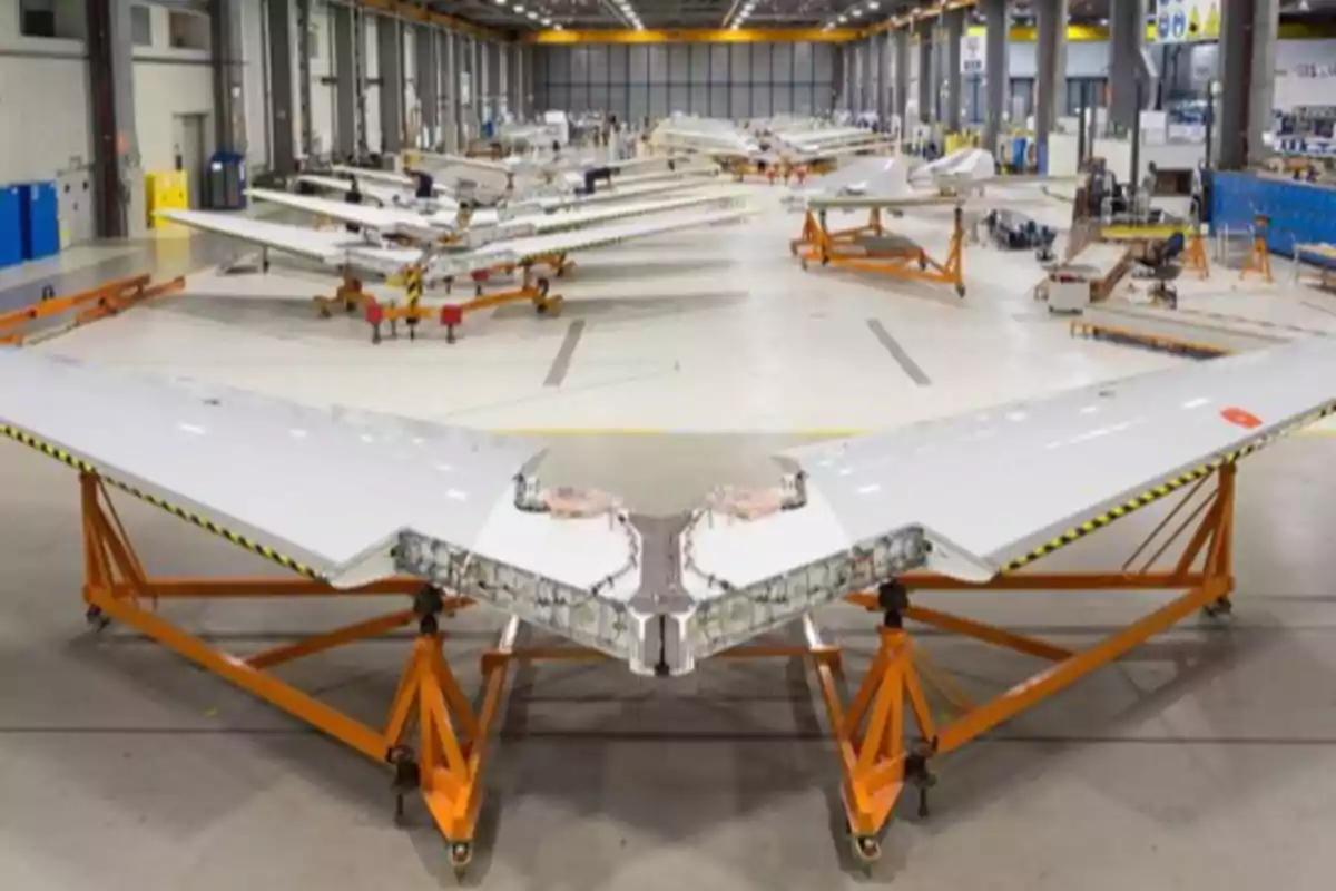 Alas de avión en proceso de ensamblaje dentro de una fábrica aeronaútica Alas de avión en proceso de ensamblaje dentro de una fábrica aeronaútica