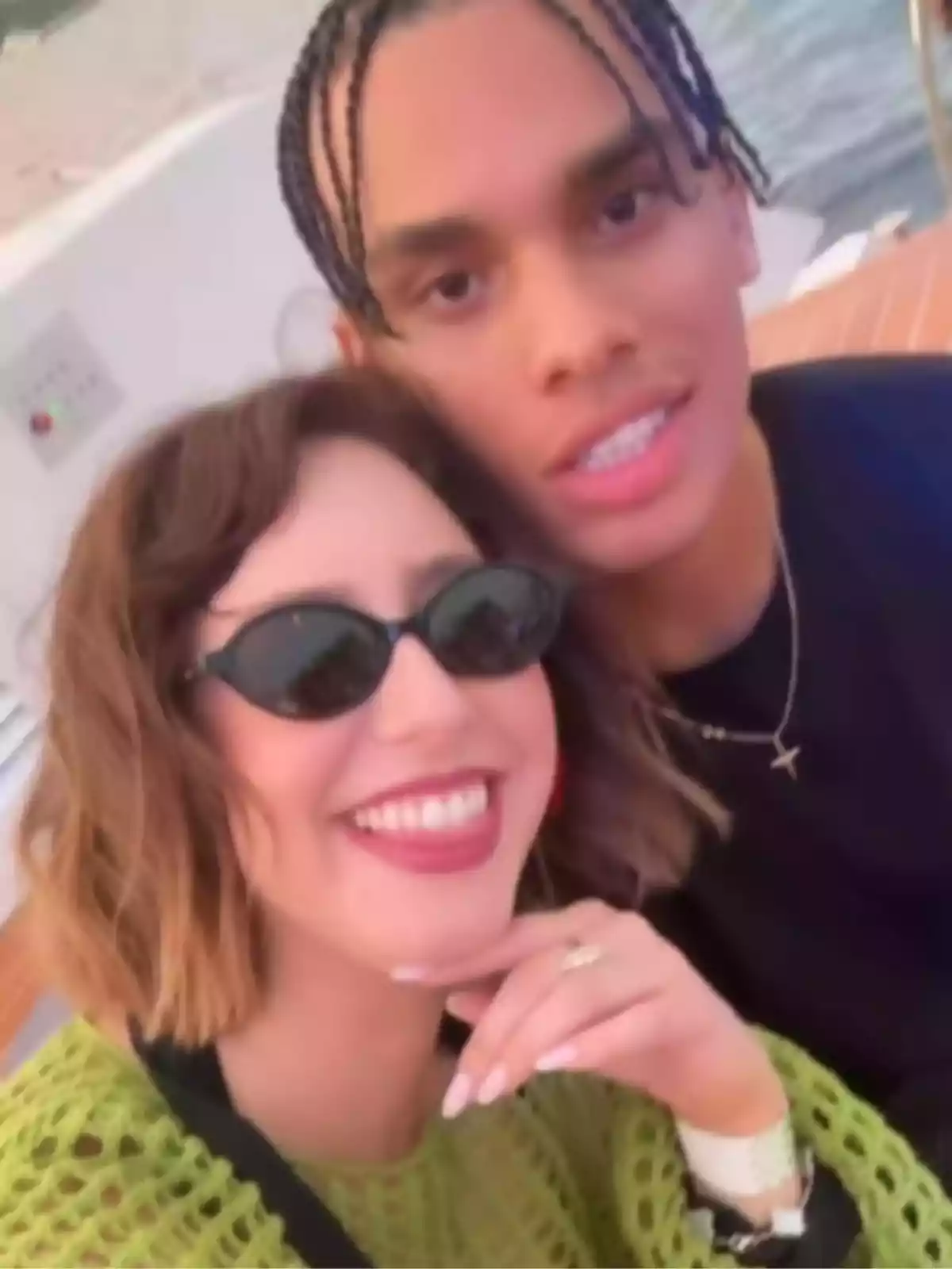 Pareja joven sonriendo mientras se toma una selfie en un lugar al aire libre cerca del agua Pareja joven sonriendo mientras se toma una selfie en un lugar al aire libre cerca del agua