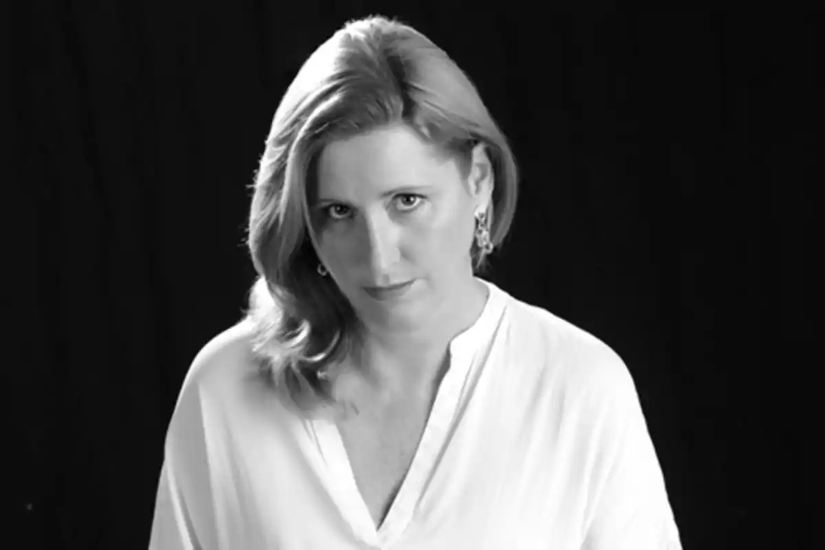 Mujer de cabello rubio y corto con blusa clara mirando al frente en una fotografía en blanco y negro con fondo oscuro Mujer de cabello rubio y corto con blusa clara mirando al frente en una fotografía en blanco y negro con fondo oscuro