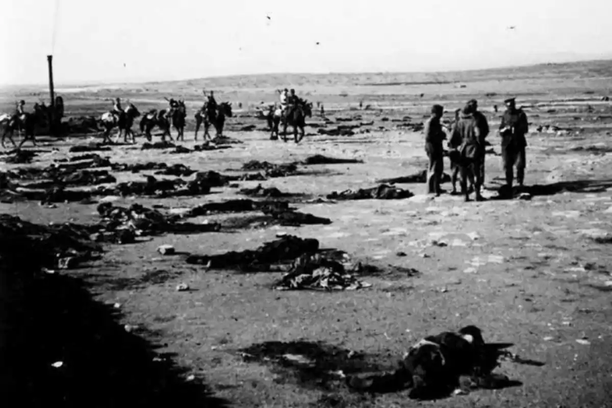 Campo desolado con cuerpos en el suelo y un grupo de personas y caballos al fondo en un ambiente árido Campo desolado con cuerpos en el suelo y un grupo de personas y caballos al fondo en un ambiente árido
