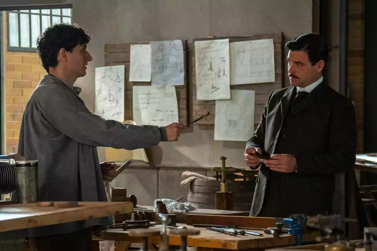 Dos hombres conversan en un taller -uno de ellos es Arturo Sancho en 'La Promesa'- rodeados de herramientas y planos técnicos pegados en la pared. Dos hombres conversan en un taller -uno de ellos es Arturo Sancho en 'La Promesa'- rodeados de herramientas y planos técnicos pegados en la pared.