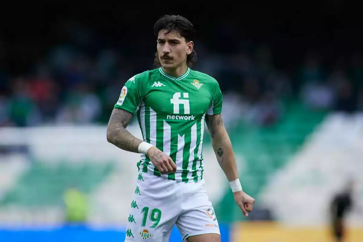 Futbolista con uniforme verde y blanco del Real Betis en el campo durante un partido