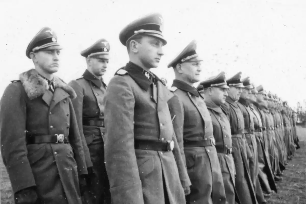 Grupo de soldados alemanes formados en fila usando uniformes y gorras militares durante la Segunda Guerra Mundial Grupo de soldados alemanes formados en fila usando uniformes y gorras militares durante la Segunda Guerra Mundial