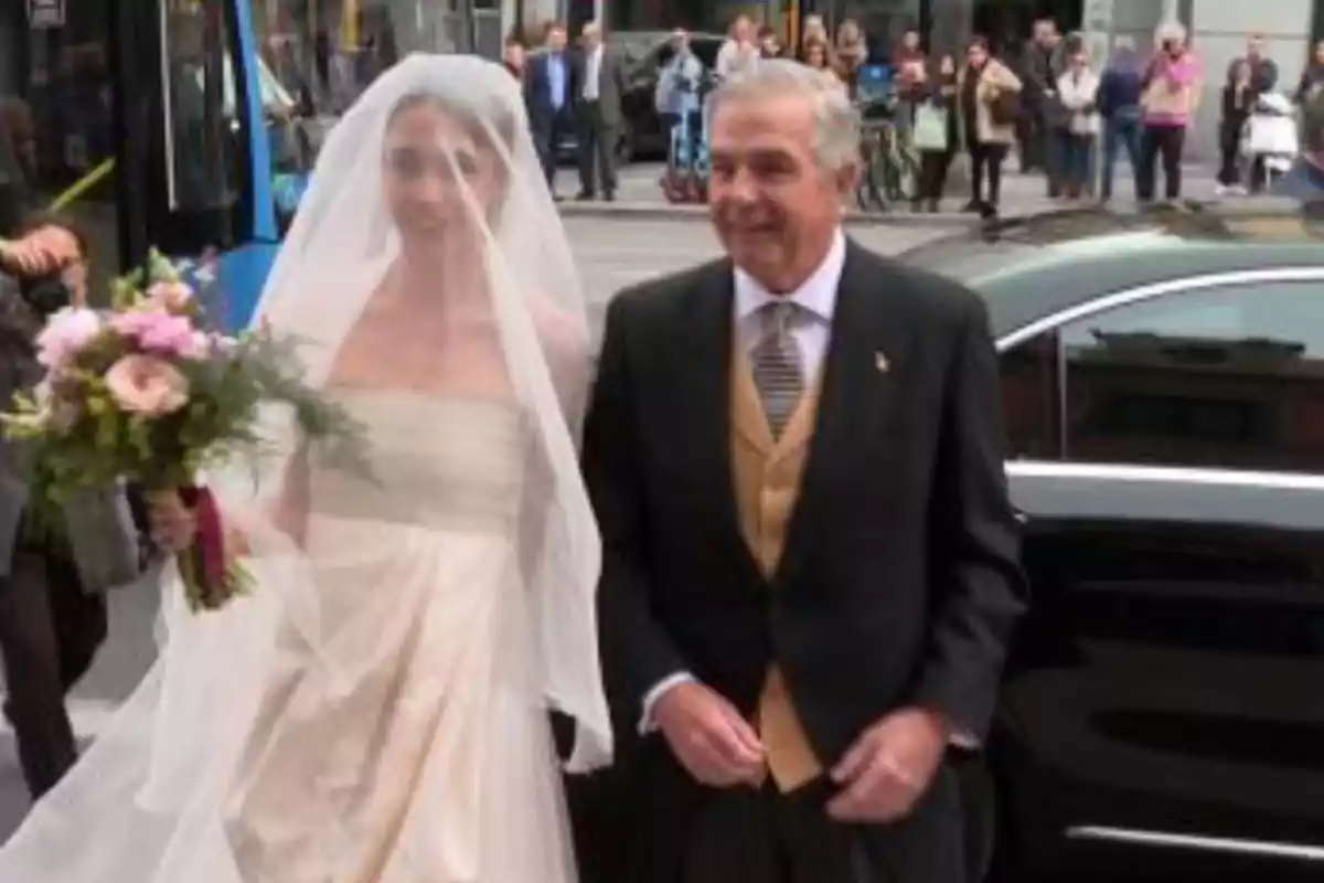 Una novia con velo y ramo de flores camina junto a un hombre mayor elegantemente vestido mientras llegan a un evento especial en la ciudad Una novia con velo y ramo de flores camina junto a un hombre mayor elegantemente vestido mientras llegan a un evento especial en la ciudad