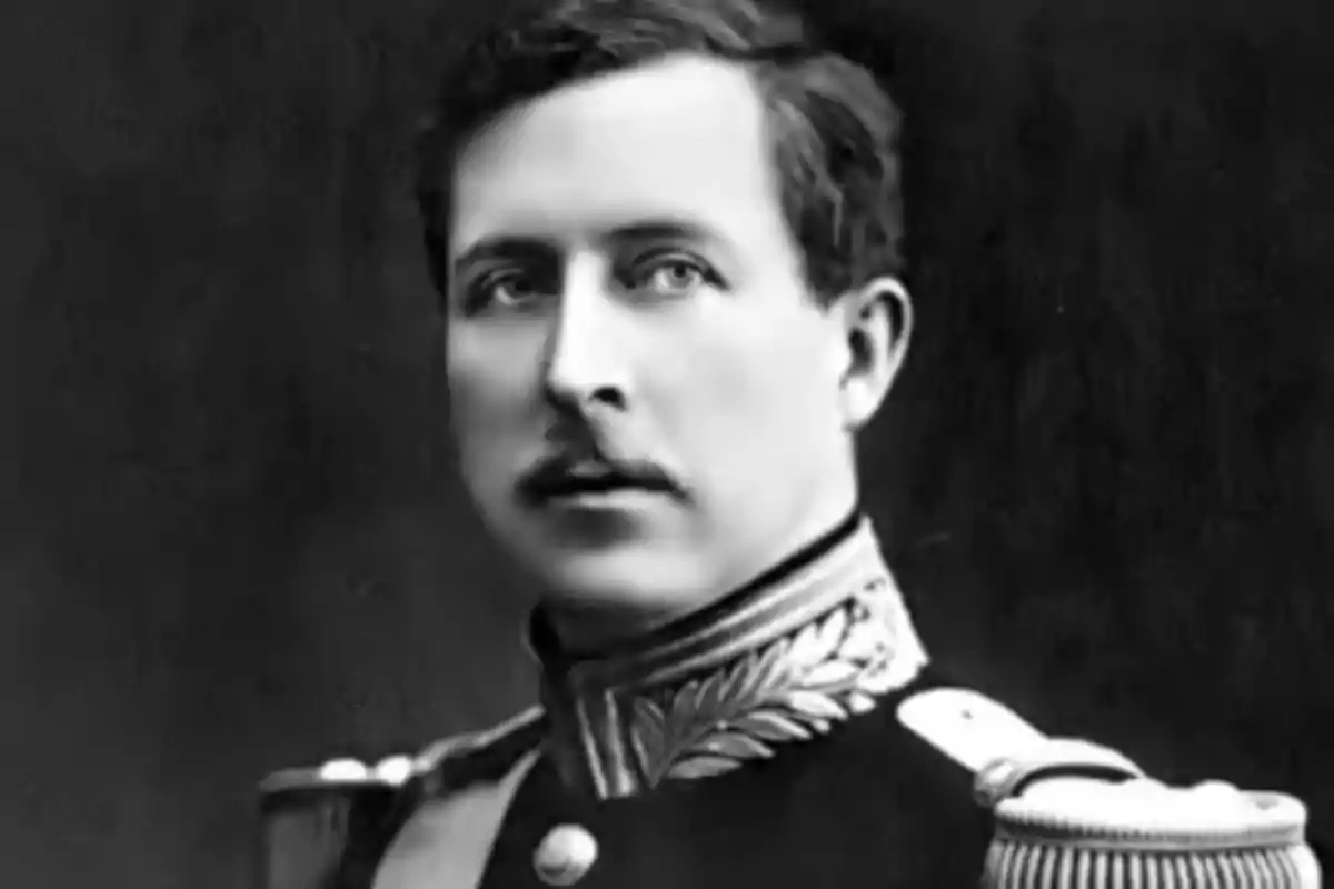 Retrato antiguo en blanco y negro de un hombre joven con uniforme militar elegante y fondo oscuro