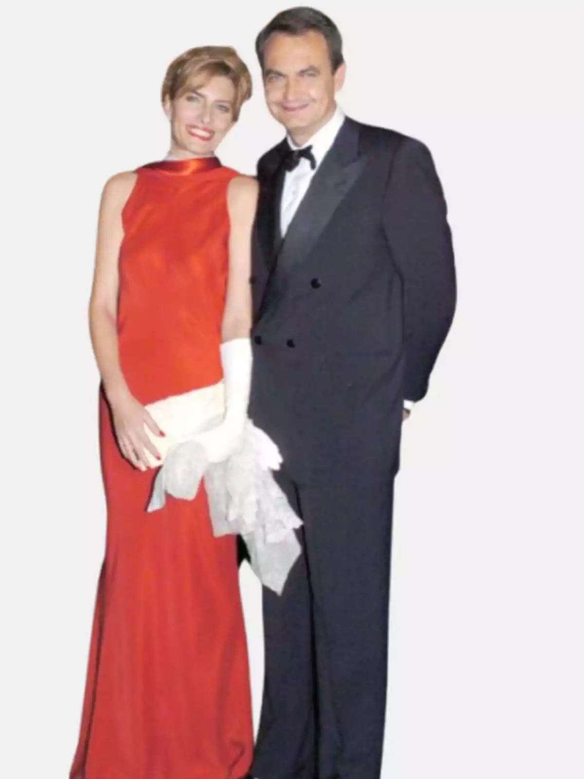 Pareja elegantemente vestida posando juntos ella con vestido rojo largo y él con esmoquin negro Pareja elegantemente vestida posando juntos ella con vestido rojo largo y él con esmoquin negro