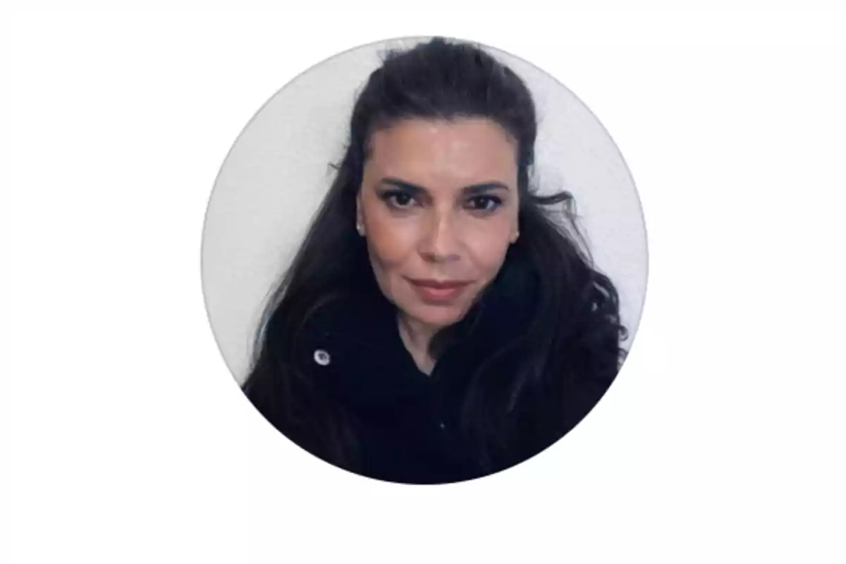 Mujer de cabello largo y oscuro con chaqueta negra mirando al frente sobre fondo blanco Mujer de cabello largo y oscuro con chaqueta negra mirando al frente sobre fondo blanco