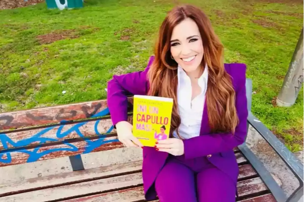 Mujer sonriente sentada en una banca de parque con traje morado sosteniendo un libro amarillo Mujer sonriente sentada en una banca de parque con traje morado sosteniendo un libro amarillo