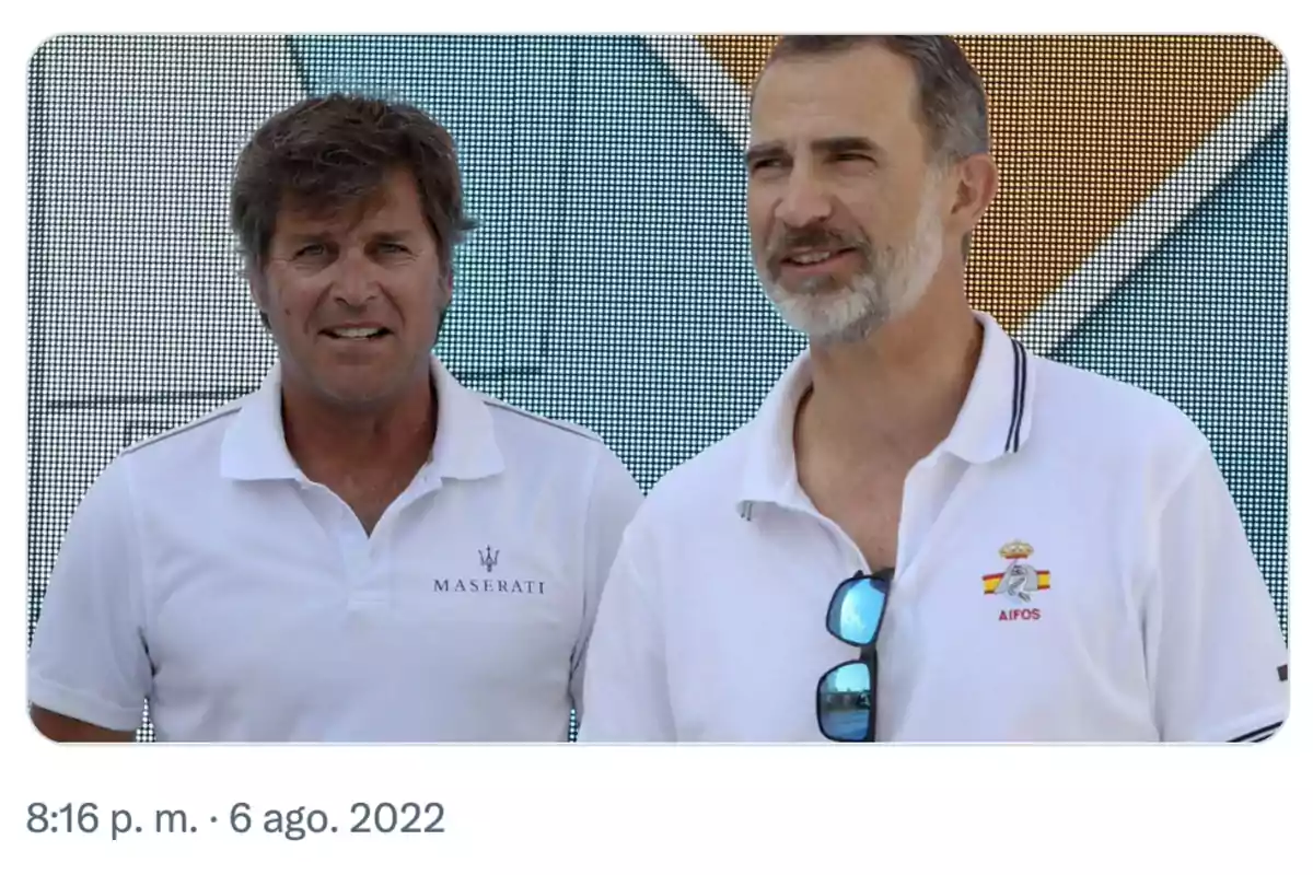 Dos hombres con camisetas tipo polo blancas posan juntos frente a un fondo colorido Dos hombres con camisetas tipo polo blancas posan juntos frente a un fondo colorido