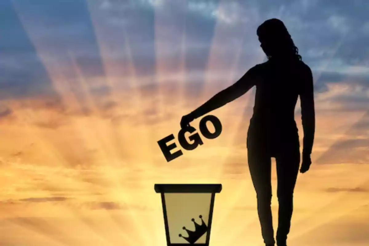 Silueta de una persona arrojando la palabra ego a un bote de basura con una corona al atardecer
