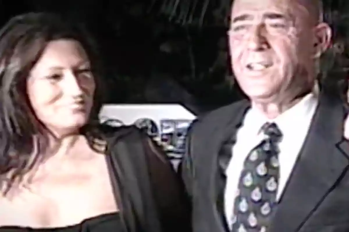 Una mujer y un hombre vestidos de manera elegante posan juntos en un evento social. Una mujer y un hombre vestidos de manera elegante posan juntos en un evento social.