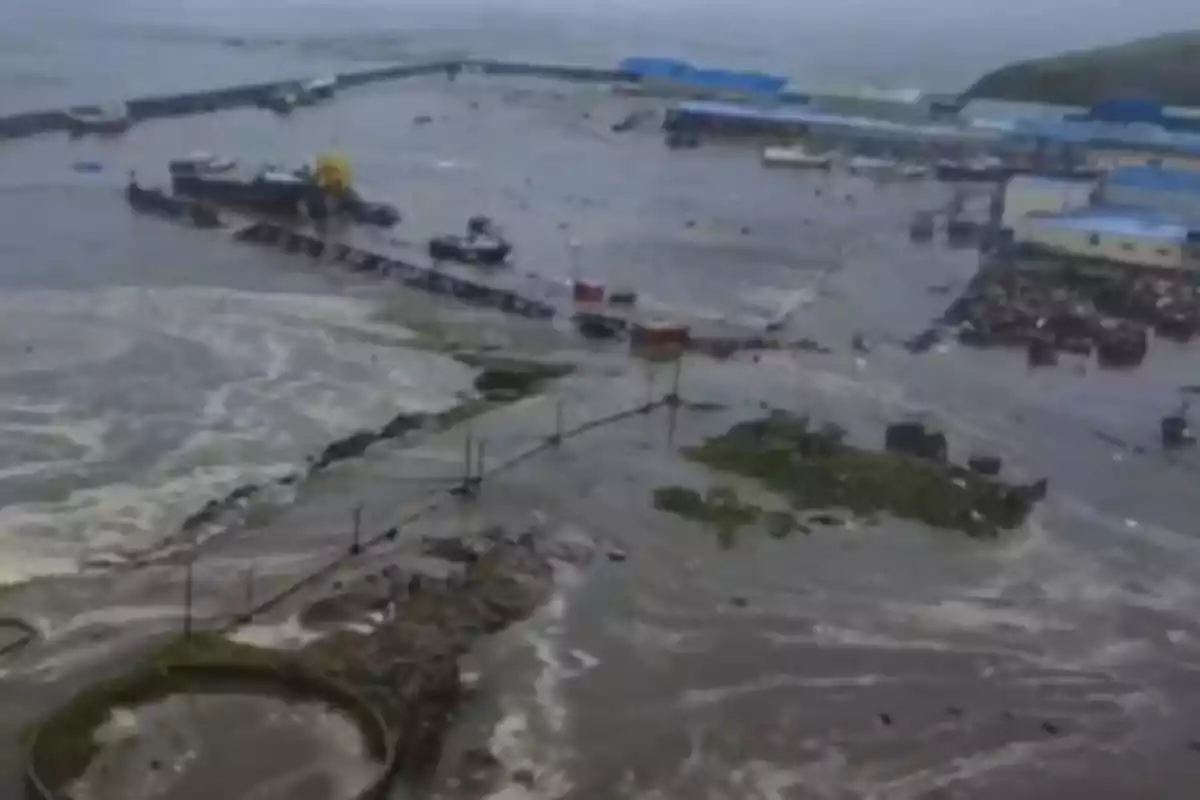 Vista aérea de un puerto inundado con estructuras dañadas y agua cubriendo gran parte del área