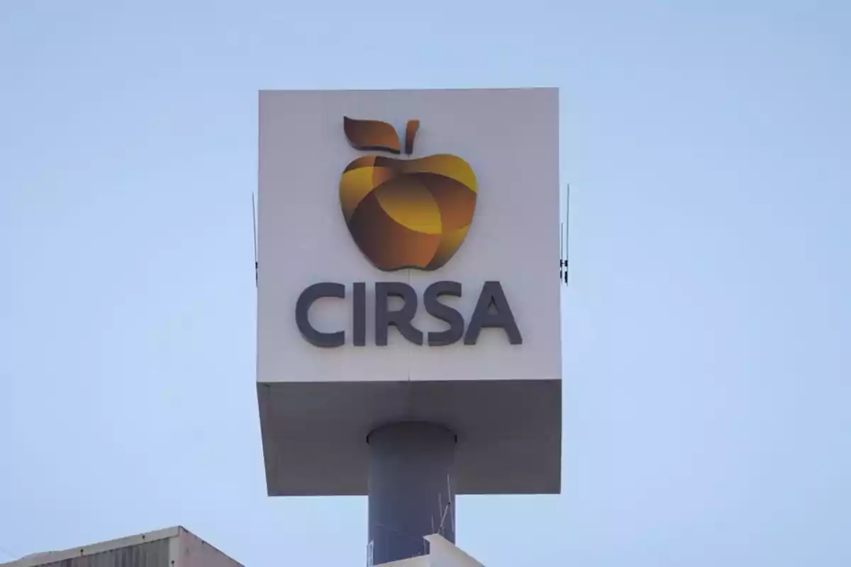 Letrero de la empresa CIRSA con un logo de manzana estilizada sobre fondo claro Letrero de la empresa CIRSA con un logo de manzana estilizada sobre fondo claro