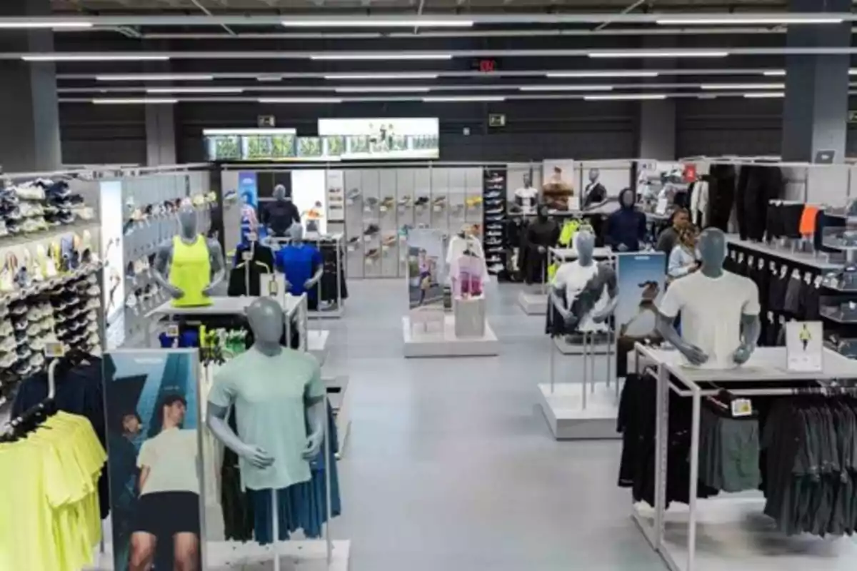 Tienda de ropa deportiva con maniquíes exhibiendo diferentes prendas y estantes llenos de productos Tienda de ropa deportiva con maniquíes exhibiendo diferentes prendas y estantes llenos de productos